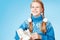 Cheerful little girl in blue warm sweater holding figure skates.