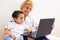 Cheerful little girl and grandma using laptop computer