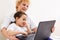 Cheerful little girl and grandma using laptop computer