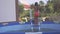 Cheerful little girl is having fun in the outdoors swimming pool. Slow Motion 240 fps. Child is jumping and playing in