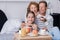 Cheerful little girl holding berry cupcakes with her grandparents