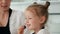 Cheerful little girl licks a berry and looking at the camera