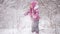 Cheerful little girl playing in a winter forest with snow drifts