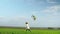 Cheerful little girl runs and playing with a kite on a green field