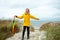 Cheerful little girl staying on beach with colorful ambrella on Baltic sea at windy weathe