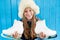 Cheerful little girl in warm sweater and hat keeps figure skates