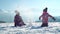 Cheerful little girls in outwear having fun and throwing snow in sunlight standing outdoors