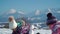 Cheerful little girls in outwear having fun and throwing snow in sunlight standing outdoors