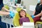 Cheerful little patient is sitting in pedodontist office before examination