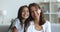 Cheerful little preschool girl and happy pretty mom sitting close