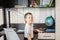 A cheerful little schoolgirl is sitting at a desk. Workplace of young pupil. Happy child getting ready to do homework. Children`s