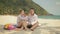 The cheerful love couple holding and eating slices of watermelon on tropical sand beach sea. Romantic lovers two people