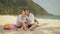 The cheerful love couple holding and eating slices of watermelon on tropical sand beach sea. Romantic lovers two people