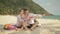 The cheerful love couple holding and eating slices of watermelon on tropical sand beach sea. Romantic lovers two people