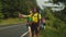 Cheerful lovely multiethnic women travelers hitchhiking on mountain road