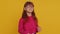 Cheerful lovely young preteen child girl kid smiling, looking at camera on studio yellow background