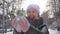 A cheerful and lovely young woman in a pink hat throws the first snow and laughs at the camera. Concept: winter vacation