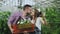 Cheerful loving couple gardeners taking selfie picture on smartphone camera and kissing while working in greenhouse