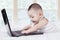 Cheerful male baby typing on laptop