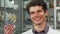 Cheerful male chemist smiling holding two blisters of pills