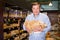 Cheerful male customer choosing pasta in supermarket