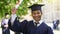 Cheerful male graduate showing certificate for camera and smiling, success