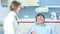 Cheerful male patient sitting in dental chair and talking with female dentist