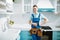 Cheerful male plumber in uniform in the kitchen