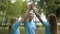 Cheerful male volunteer giving high-five to beautiful young women in summer park. Happy Caucasian group of people taking