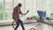 Cheerful man is engaged in cleaning and imagines that he plays the guitar