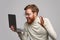 Cheerful man looking at laptop with prize