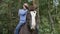 Cheerful man sitting on horse and laughing in forest