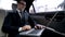 Cheerful man in suit having video call, riding on backseat of car, conversation