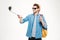 Cheerful man taking pictures with mobile phone and selfie stick