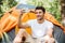 Cheerful man tourist taking selfie with mobile phone in forest