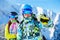 Cheerful man and woman snowboarders standing on snow resort against backdrop of mountain