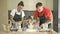 Cheerful married couple with a little daughter, cook some dough together, enjoy family activities.