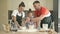 Cheerful married couple with a little daughter, cook some dough together, enjoy family activities.