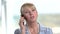 Cheerful mature blonde talking on phone.