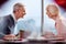 Cheerful mature couple chatting at table