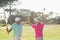 Cheerful mature golfer couple giving high five