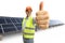 Cheerful mature male engineer showing thumbs up in front of a photovoltaic field