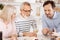 Cheerful mature son enjoying family dinner at home