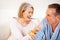 Cheerful mature woman feeding muffin to her husband. Portrait of a cheerful mature woman feeding muffin to her husband.