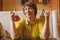 Cheerful mid adult woman with olive oil and balsamic vinegar bottles in italian cafe