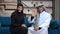 Cheerful Middle Eastern husband and wife in traditional clothing waving smiling looking at camera talking. Positive