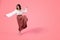 Cheerful millennial caucasian woman brunette barefoot dancing, isolated on pink background, studio, full length