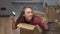 Cheerful millennial Caucasian woman with toothy smile having fun sitting in cardboard box showing toy house and key