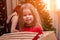 Cheerful mischievous girl posing in box from under the Christmas