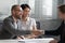 Cheerful mixed race married spouse shaking hands with real estate agent.